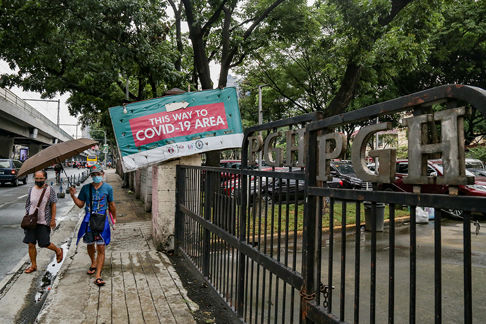 Pedestrians walk near the gates of the Philippine General Hospital (PGH) in Manila on August 24, 2021. George Calvelo, ABS-CBN News/File