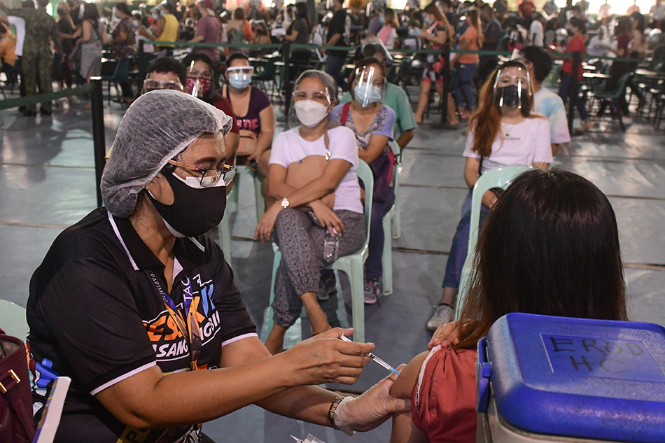 Caloocan City residents booked online receive their dose of a COVID-19 vaccine