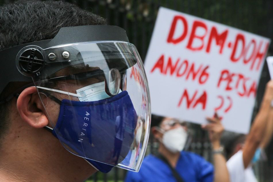 Health workers and frontline employees of the University of Santo Tomas Hospital wear face shields while holding a protest along Espańa Avenue in Manila on August 30, 2021.