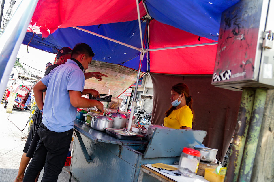 Workers dine at a food stall along a busy road in Sta. Ana, Manila on August 18, 2021. Despite the implemented enhanced community quarantine (ECQ) since August 6, Health Undersecretary Maria Rosario Vergeire said on Aug 17 that a DOH analysis showed 39 percent more mobility of people during this year’s ECQ compared to the previous ones. George Calvelo, ABS-CBN News