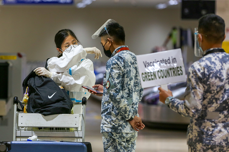 Philippine Coast Guard personnel ask travelers for pertinent documents and information as they arrive at the Ninoy Aquino International Airport (NAIA)Terminal 1 in Parañaque City on July 1, 2021. Jonathan Cellona, ABS-CBN News/File 