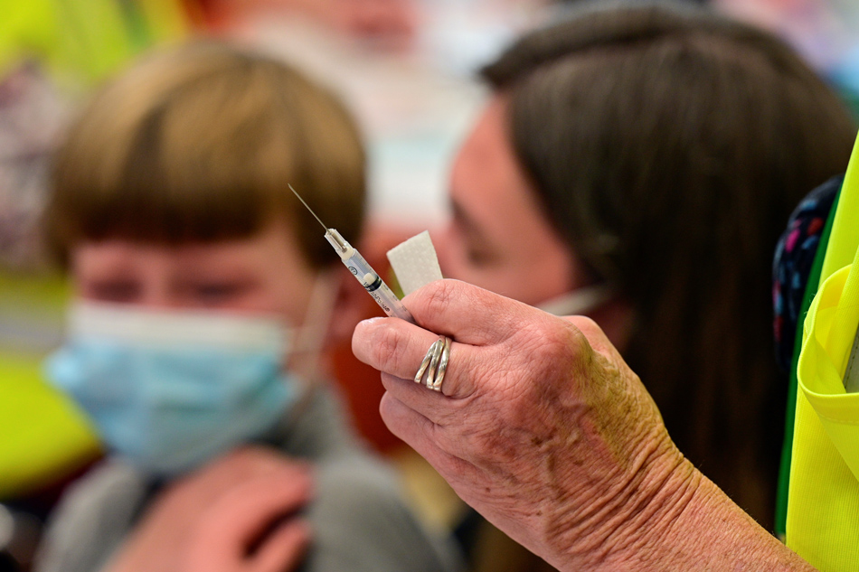A child is seen near a syringe containing a dose of the Pfizer-BioNTech coronavirus disease (COVID-19) vaccine at Smoketown Family Wellness Center in Louisville, Kentucky, November 8, 2021. Jon Cherry, Reuters