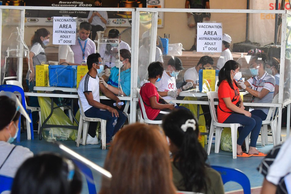 Quezon City residents receive their COVID-19 vaccine dose at the Batasan Hills National High School on November 29, 2021, the start of the 