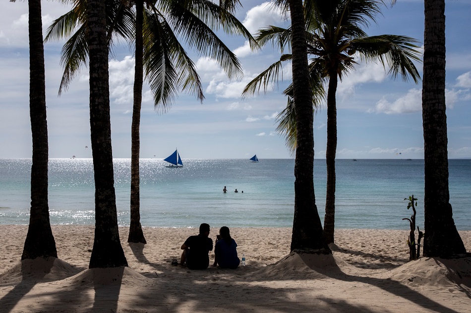 A couple enjoys a view of White Beach amid the coranavirus disease (COVID-19) outbreak, in Boracay Island, Aklan province, Philippines, November 29, 2021. Picture taken November 29, 2021. Eloisa Lopez, Reuters