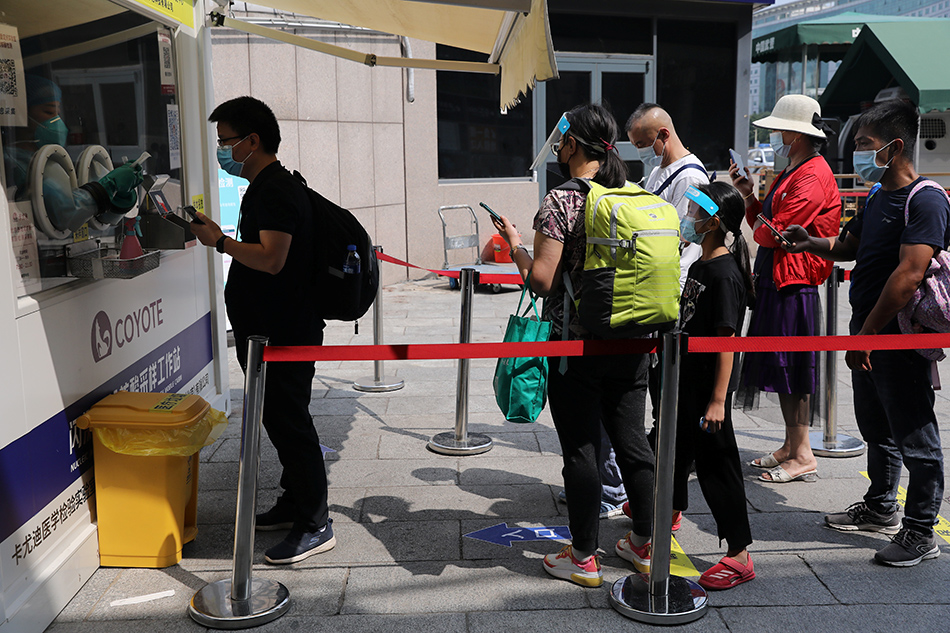 People line up at a mobile nucleic acid testing site at a railway station, following new cases of the coronavirus disease (COVID-19), in Beijing, China August 6, 2021.
