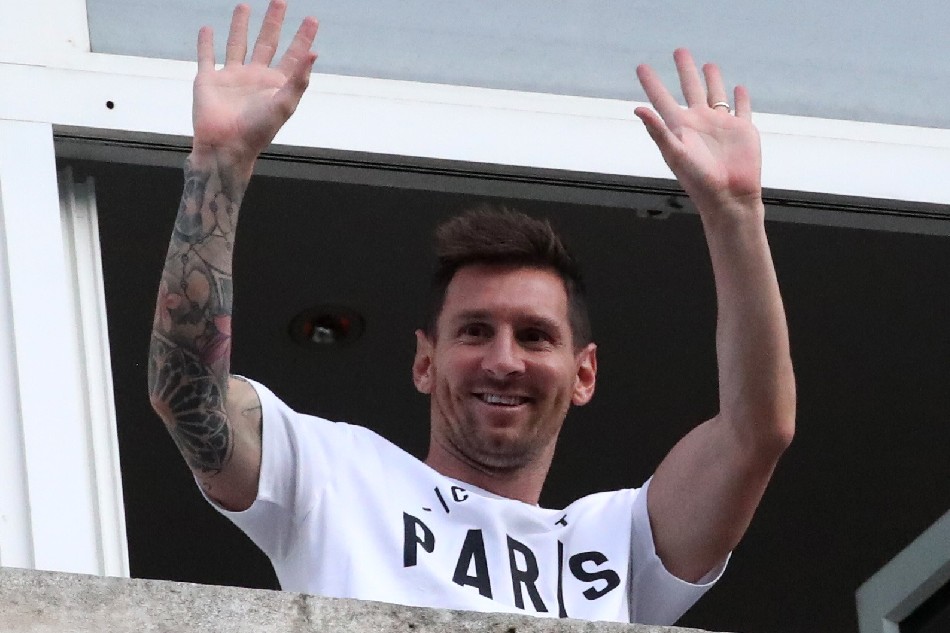 Lionel Messi waves from the balcony of the Royal Monceau Hotel. Yves Herman, Reuters