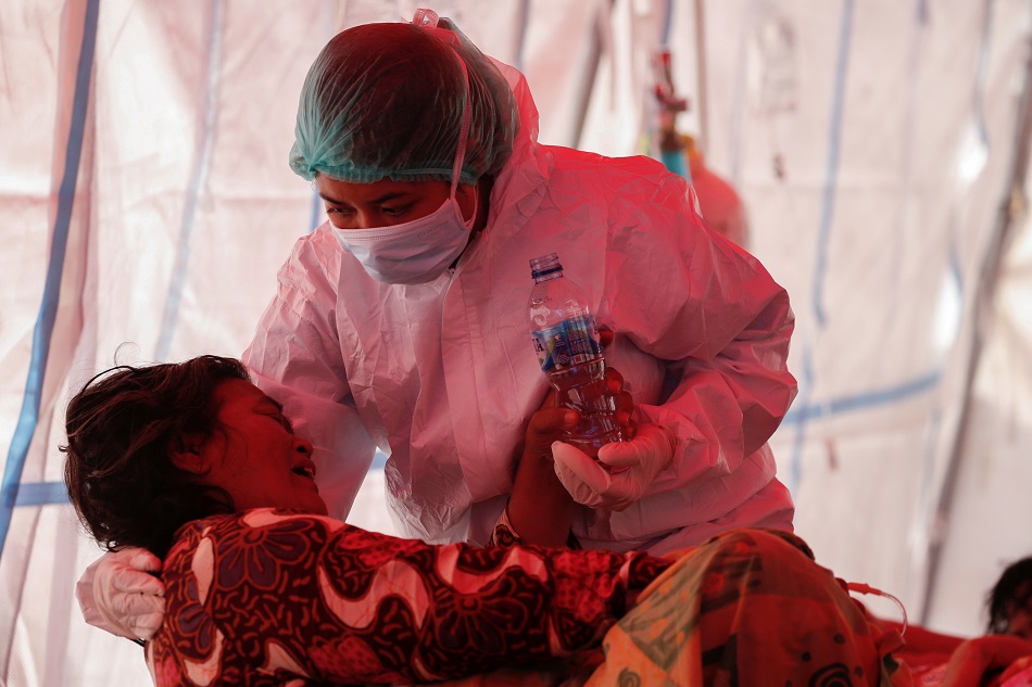 A healthcare worker in personal protective equipment ) treats a patient inside a temporary tent erected outside a hospital emergency ward amid the surge of coronavirus disease (COVID-19) in Bekasi, on the outskirts of Jakarta, Indonesia, July 15, 2021.  