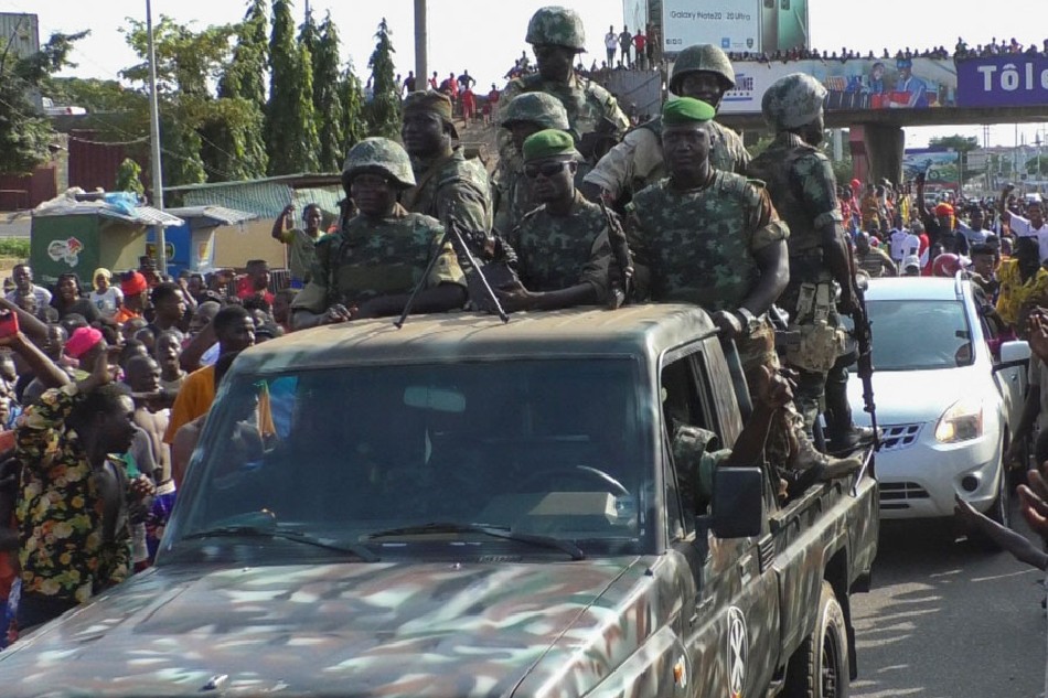 Residents cheer at army soldiers as they celebrate the uprising in Conakry, Guinea September 5, 2021. Souleymane Camara, Reuters