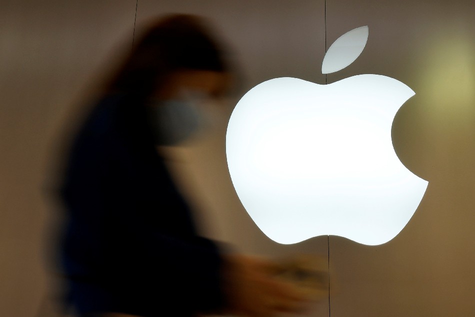 A woman walks past an Apple logo in front of an Apple store in Saint-Herblain near Nantes, France, September 16, 2021. Stephane Mahe, Reuters/File