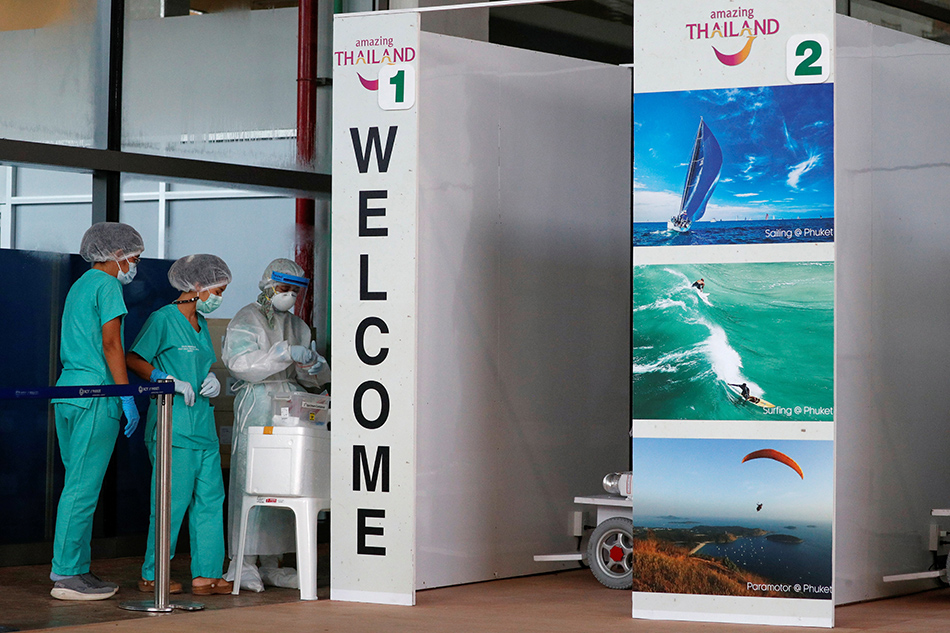 Health workers stand at the COVID-19 swab test area at the airport as Phuket reopens to overseas tourists, allowing foreigners fully vaccinated against the coronavirus disease (COVID-19) to visit the resort island without quarantine, in Phuket, Thailand July 1, 2021.