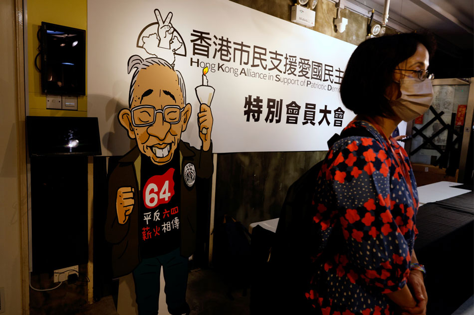 A person stands in front of a logo of the Hong Kong Alliance in Support of Patriotic Democratic Movements of China and a cut out of Szeto Wah, the late founding chairman of the group, at the June 4th Museum, in Hong Kong, China on September 25, 2021. Tyrone Siu, Reuters/file