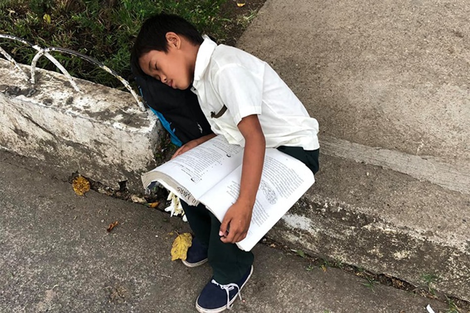 VIRAL: Boy sleeps while studying, selling sampaguita outside church 1