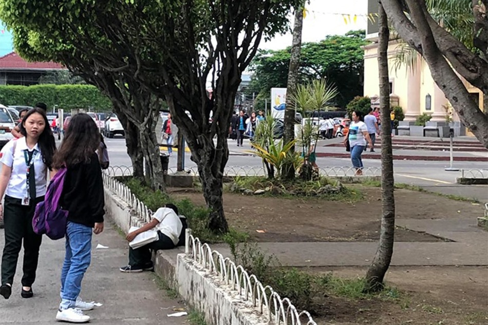 VIRAL: Boy sleeps while studying, selling sampaguita outside church 2