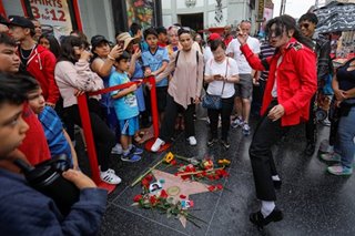 Jackson fans sing, sob, leave sunflowers and roses on 10th anniversary of death