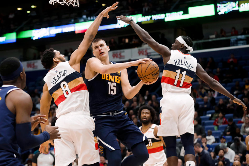 Jokic busca el aro entre Okafor y Holiday.