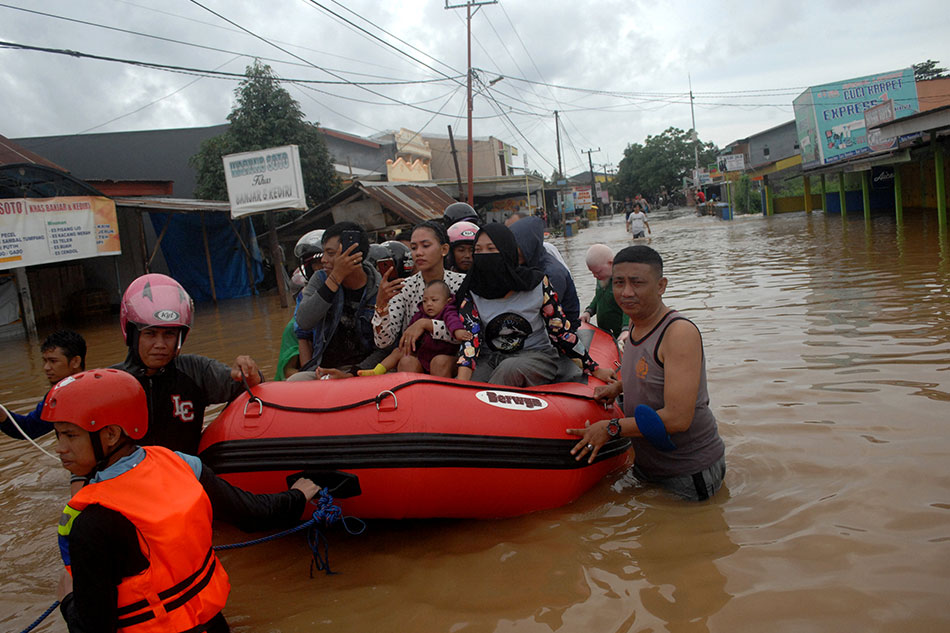 Rescue workers push an inflatable boat as they evacuate residents following floods in Makassar, South Sulawesi, Indonesia, January 23, 2019 in this photo taken by Antara Foto.