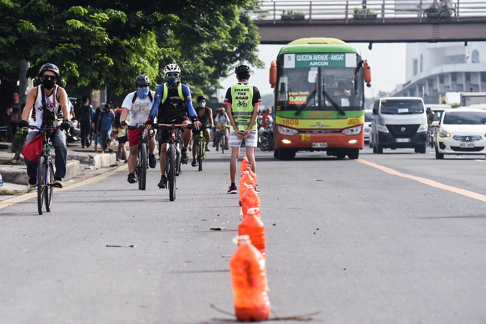 A volunteer marshal assists bicyclists along Commonwealth Avenue in Quezon City on June 27, 2020. The MMDA and various groups are promoting cycling and sustainable mobility during a three-day road sharing experience along Commonwealth Avenue starting Saturday. George Calvelo, ABS-CBN News