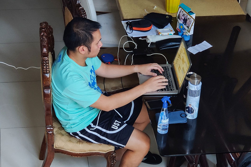 A merchant associate for a financial technology company works from his home in Quezon City on March 18, 2020, amid the enhanced community quarantine for the whole of Luzon. Mark Demayo, ABS-CBN News