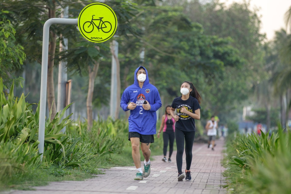 People wearing face masks exercise along Roxas Boulevard. Czar Dancel, ABS-CBN News