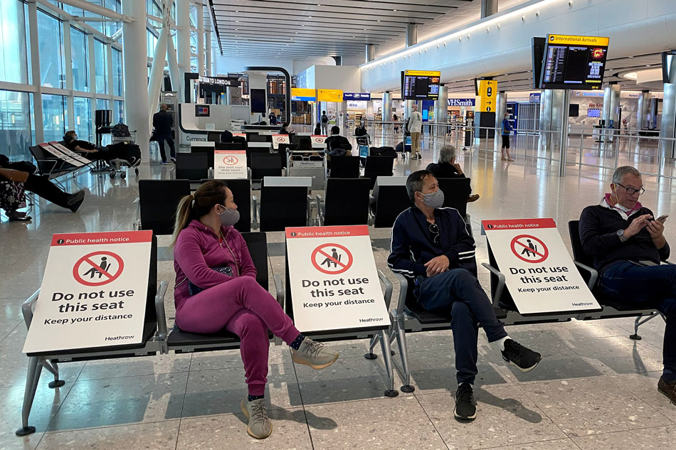 People sit amongst socially-distanced seating signs at Heathrow Airport, as the spread of the coronavirus disease (COVID-19) continues, in London, Britain, May 10, 2020. Toby Melville, Reuters file photo