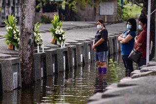LOOK: Despite floods, relatives visit loved ones in Pampanga cemetery