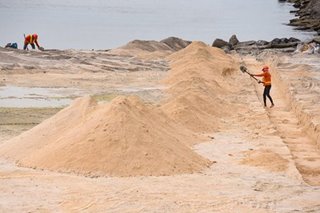 Workers replenish dolomite in Manila Bay