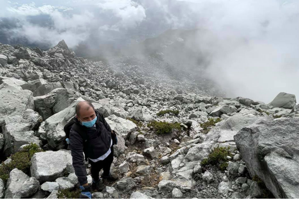 A climber wears a face mask while hiking across Mt. Apo’s boulders as protection against the novel coronavirus as well as fumes from the sulfur vents. Hernel Tocmo, ABS-CBN News/File