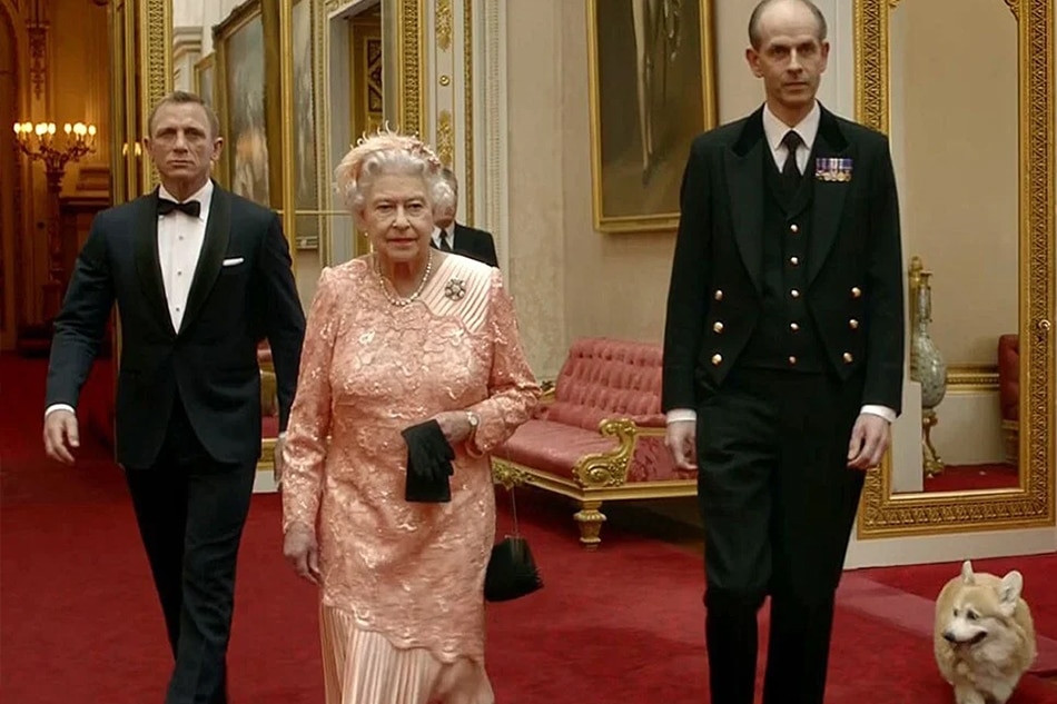 British actor Daniel Craig, playing James Bond, escorts Britain’s Queen Elizabeth through the corridors of Buckingham Palace. AFP Photo/LOCOG