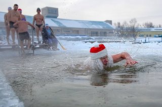 Santa swims in ice cold water