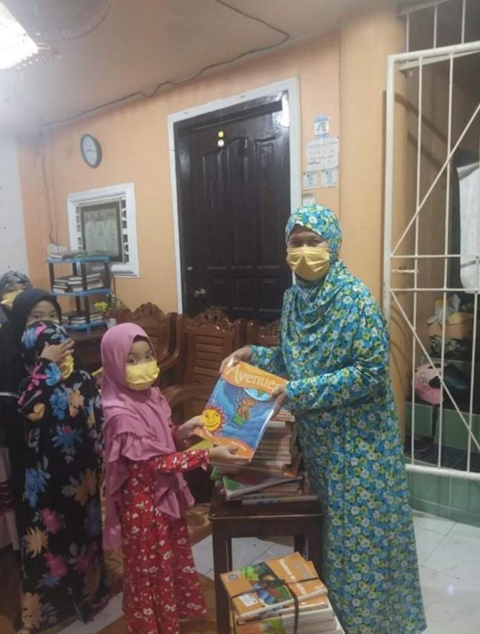 Members of the Davao City Muslim Women's Cooperative and their daughters receive books from The SM Store's 'Donate A Book' program. Photo source: SM