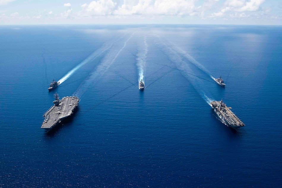 This US Navy photo obtained October 7, 2019 shows the aircraft carrier USS Ronald Reagan (CVN 76)(L), and the amphibious assault ship USS Boxer (LHD 6) and ships from the Ronald Reagan Carrier Strike Group and the Boxer Amphibious Ready Group underway in formation while conducting security and stability operations in the US 7th Fleet area of operations on October 6, 2019 in the South China Sea. Erwin Jacob V. Miciano, Navy Office of Information via AFP/File