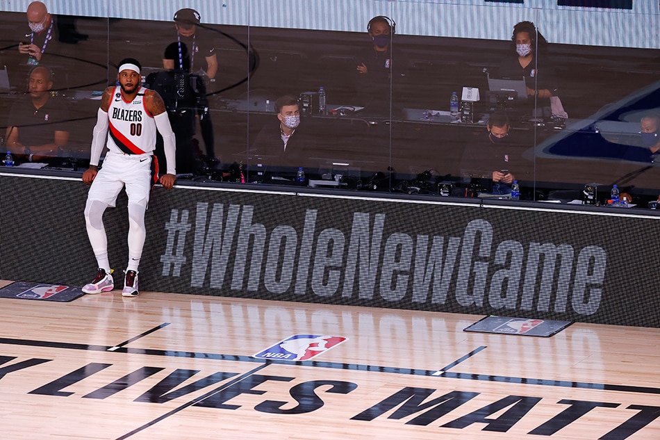 Carmelo Anthony #00 of the Portland Trail Blazers leans on the #WholeNewGame signage during the third quarter against the Los Angeles Lakers in Game Four of the Western Conference First Round during the 2020 NBA Playoffs at AdventHealth Arena at ESPN Wide World Of Sports Complex on August 24, 2020 in Lake Buena Vista, Florida. File photo. Kevin C. Cox, 