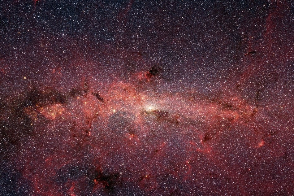 :::CAPTION-- This NASA image released on October 9, 2019 shows the center of our Milky Way galaxy, as the Spitzer Space Telescope's infrared cameras penetrate much of the dust, revealing the stars of the crowded galactic center region. - The center of our galaxy is a crowded place: A black hole weighing 4 million times as much as our Sun is surrounded by millions of stars whipping around it at breakneck speeds. This extreme environment is bathed in intense ultraviolet light and X-ray radiation. Yet much of this activity is hidden from our view, obscured by vast swaths of interstellar dust. Photo by HO/NASA/AFP/file