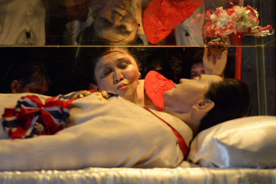 Former Philippine first lady and now congresswoman, Imelda Marcos, kisses the glass case of her late husband president Ferdinand Marcos during a visit to the mausoleum on her 85th birthday in Batac town, Ilocos norte, north of Manila on July 2, 2014. Ted Aljibe, Agence France-Presse