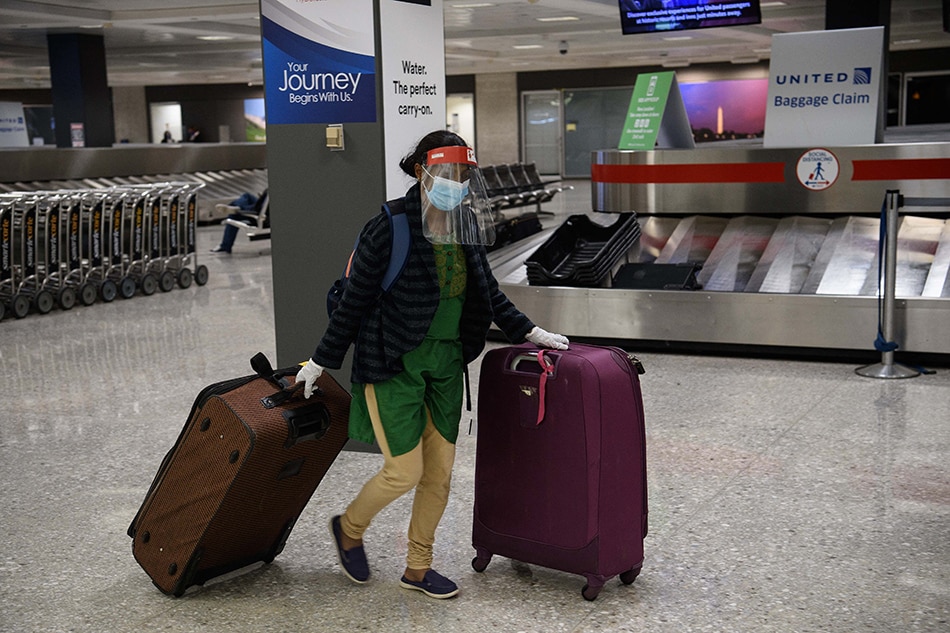 In this file photo taken on November 24, 2020, a woman wheels her luggage at Washington's Dulles International Airport in Dulles, Virginia. The US announced on October 15, 2021, that it will allow entry to foreign travelers who are fully vaccinated against Covid-19, by both land and air, starting November 8. Nicholas Kamm, AFP/File
