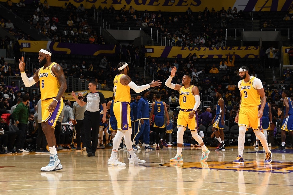 LeBron James #6, Carmelo Anthony #7, Russell Westbrook #0 and Anthony Davis #3 of the Los Angeles Lakers high five during a preseason game against the Golden State Warriors on October 12, 2021 at STAPLES Center in Los Angeles, California. Andrew D. Bernstein, NBAE via Getty Images/AFP