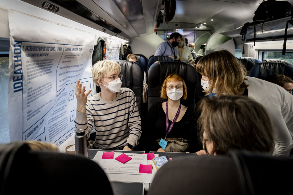 Passengers chat in a special Climate Summit train, which runs from Amsterdam Central, via Rotterdam and Brussels to London on October 30, 2021. From there, the passengers traveled on another train to Glasgow for the annual UN Climate Change Conference (COP26). Remko de Waal / ANP / AFP