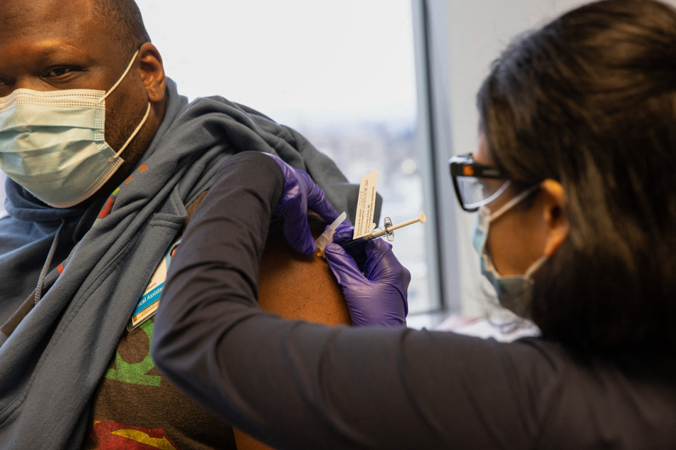 Dr. Stephaun Wallace, who leads the global external relations strategies COVID-19 Prevention Network at the Fred Hutchinson Cancer Research Center, receives his second injection from Dr. Tia Babu during the Novavax COVID-19 vaccine phase 3 clinical trial at the UW Virology Research Clinic on Feb. 12, 2021 in Seattle, Washington. The Covovax/Novavax vaccine requires standard refrigeration temperatures, making it easier to store and distribute than those requiring ultra-freezing temperatures. Karen Ducey, Getty Images/AFP/File