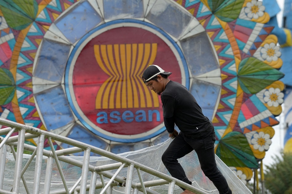 A worker balances on a metal frame next to a giant lantern decorated with the Association of Southeast Asian Nations (ASEAN) logo near the venue of the ASEAN Regional Forum meeting in Manila on August 3, 2017. Ted Aljibe, AFP/file
