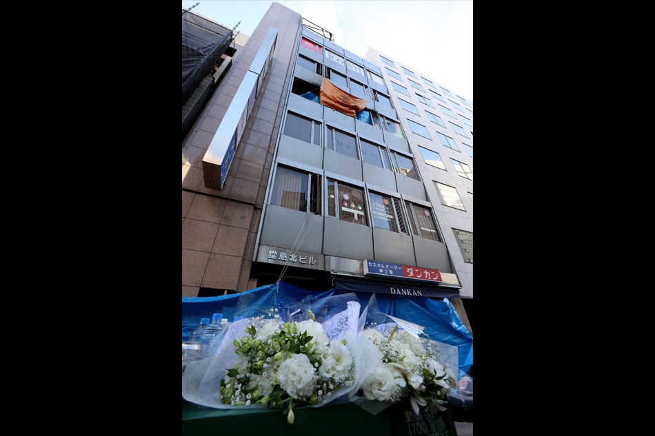Flowers are placed in front of an office building, where a fire broke out the previous day, in Osaka on December 18, 2021. STR, Jiji Press via AFP