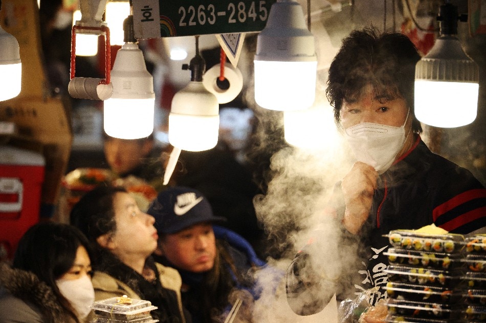 A shopkeeper waits for customers at a traditional market in Seoul, South Korea, January 14, 2022. Kim Hong-Ji, Reuters