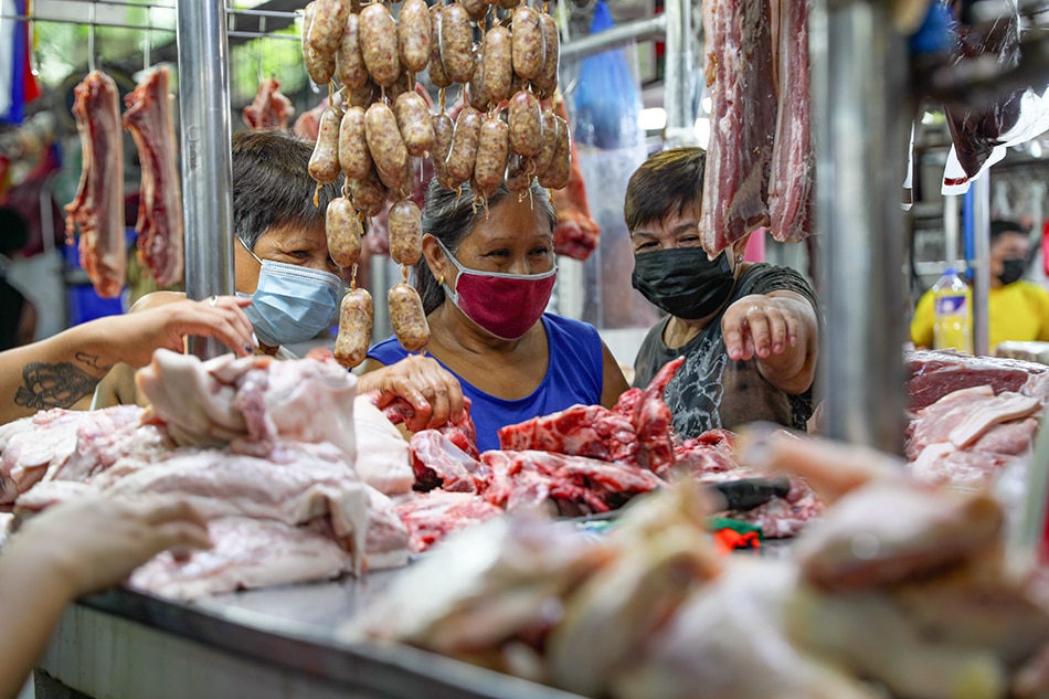 Women check pork meat products at the Paco Market in Manila on May 06, 2021. Jonathan Cellona, ABS-CBN News
