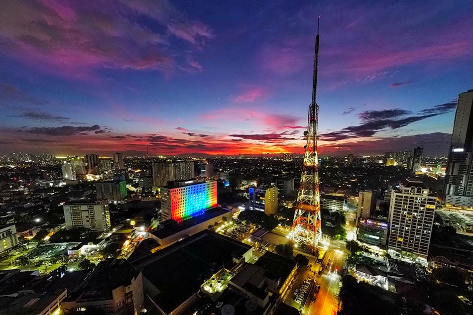 The ABS-CBN ELJ building in Quezon City lights up in the network’s colors on the eve of the first year anniversary of the denial of its franchise renewal at the hands of the House of Representatives on July 9, 2021. Basilio H. Sepe, ABS-CBN News/File