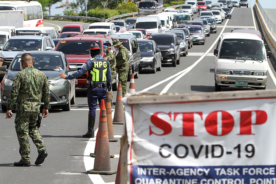 Police officers monitor motorists passing through a checkpoint between Las Piñas and Bacoor City in Cavite. ABS-CBN News/File