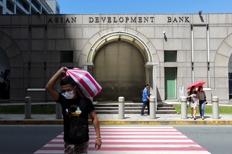 People pass in front of the Asian Development Bank (ADB) headquaters in Ortigas Pasig City on March 12, 2020. Jonathan Cellona, ABS-CBN News