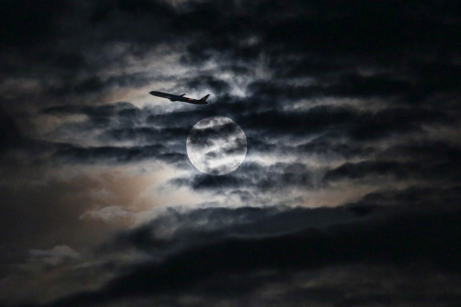 An airplane passes across the face of the moon. Gigie Cruz, ABS-CBN News file photo 
