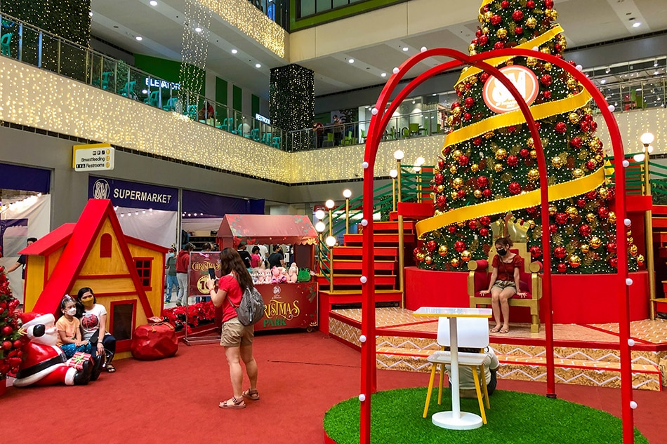 People take pictures with the Christmas installations at SM BF in Parañaque City on November 6, 2021. Several Filipinos went out on the first weekend since restrictions were eased down to alert level 2, allowing all ages inside malls and public places. George Calvelo, ABS-CBN News