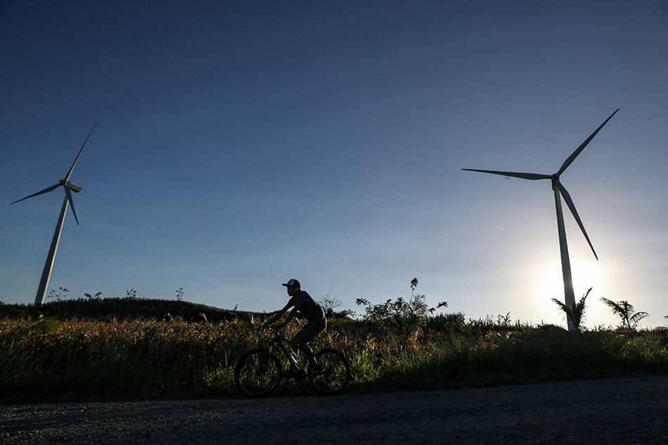 A cyclist passes by Wind Mills at the Pililla Wind farm in Rizal, March 5, 2018.
