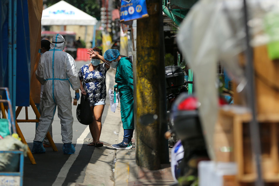 A resident passes a scurity check as the street is placed under granular lockdown in Brgy. Tejeros in Makati City on September 17, 2021. Jonathan Cellona, ABS-CBN News