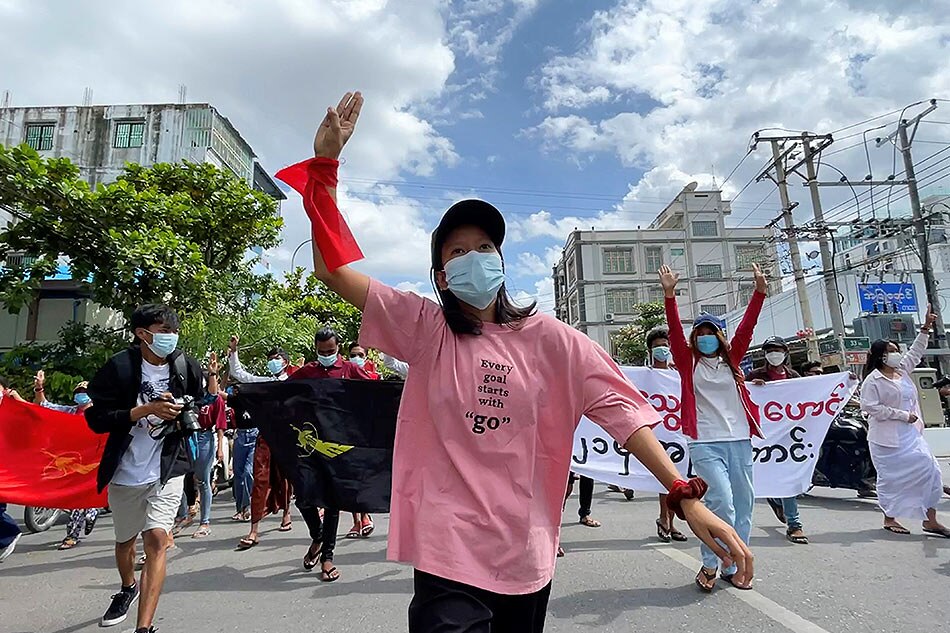 An anti-coup protester shows the three-finger salute during a march on the anniversary of a 1988 uprising, in Mandalay, Myanmar August 8, 2021 in this still image obtained by Reuters from a social media video.